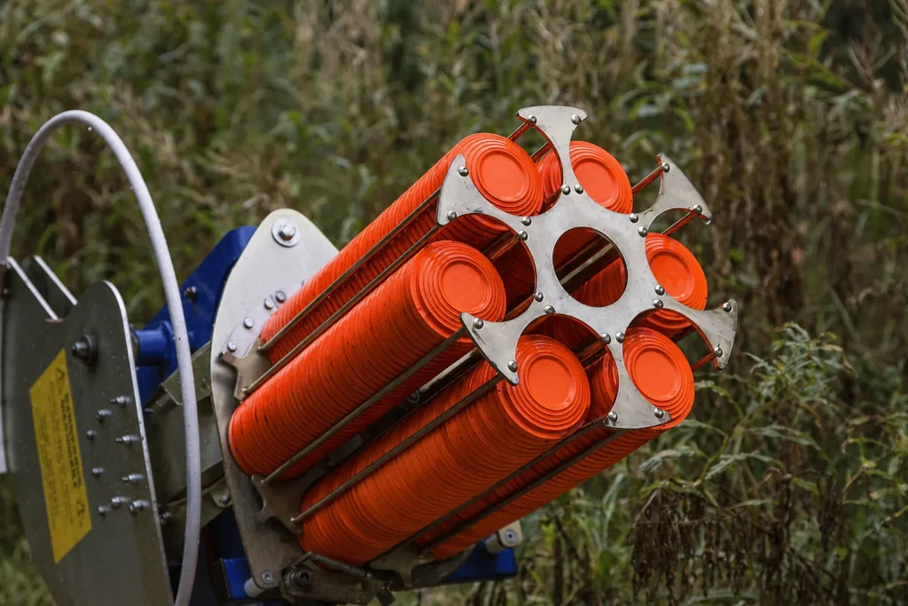 Clay target thrower loaded with orange clays